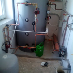 Akumulační nádoba se systémem k teplovodnímu krbu.